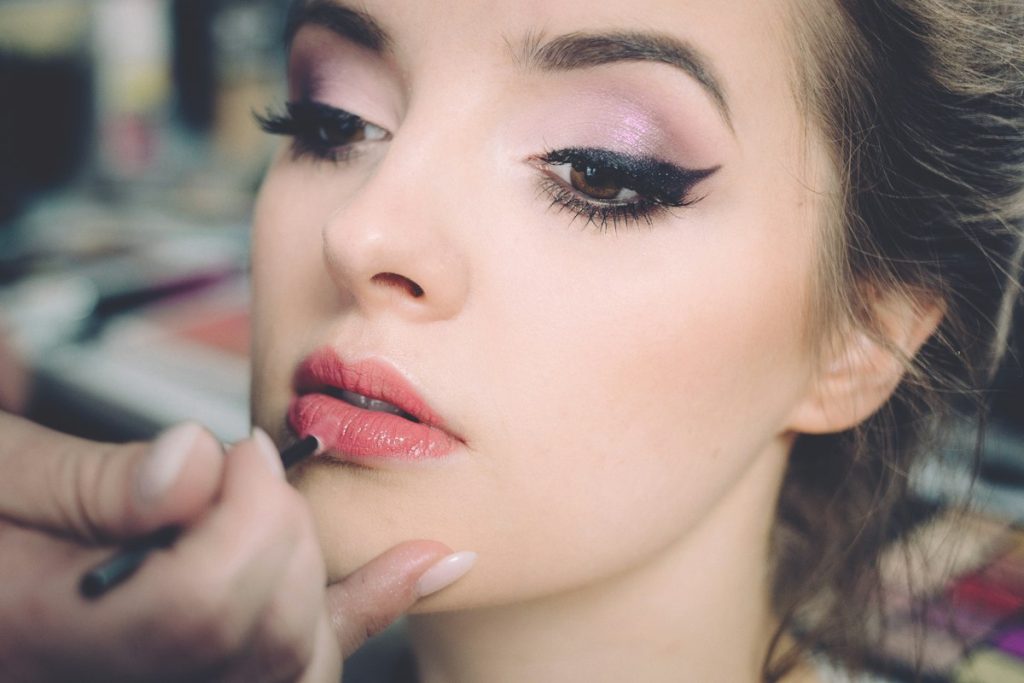 Makeup artist in Majan: makeup artist applying lipstick