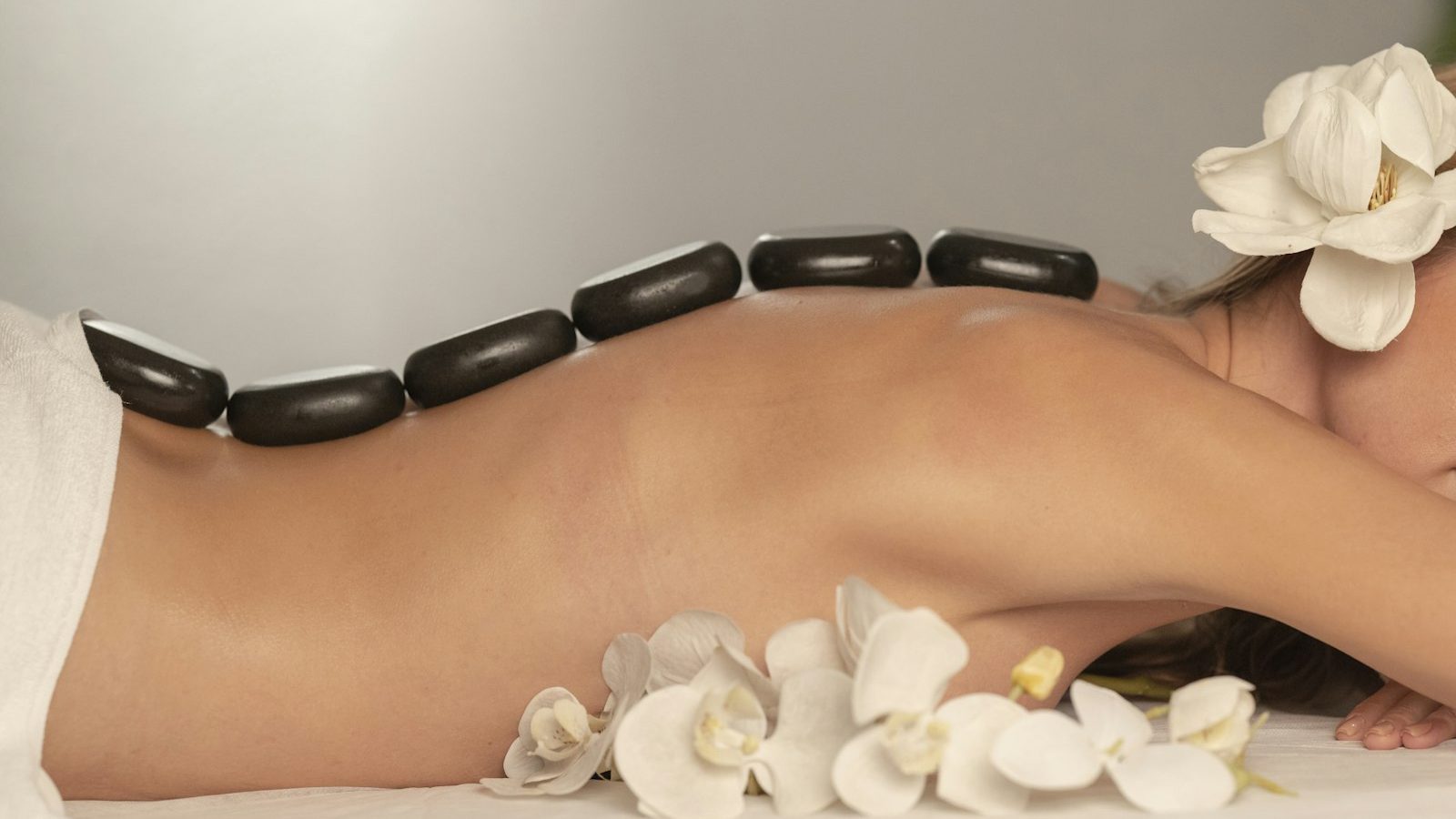 Full body massage: hot stone massage with white orchids