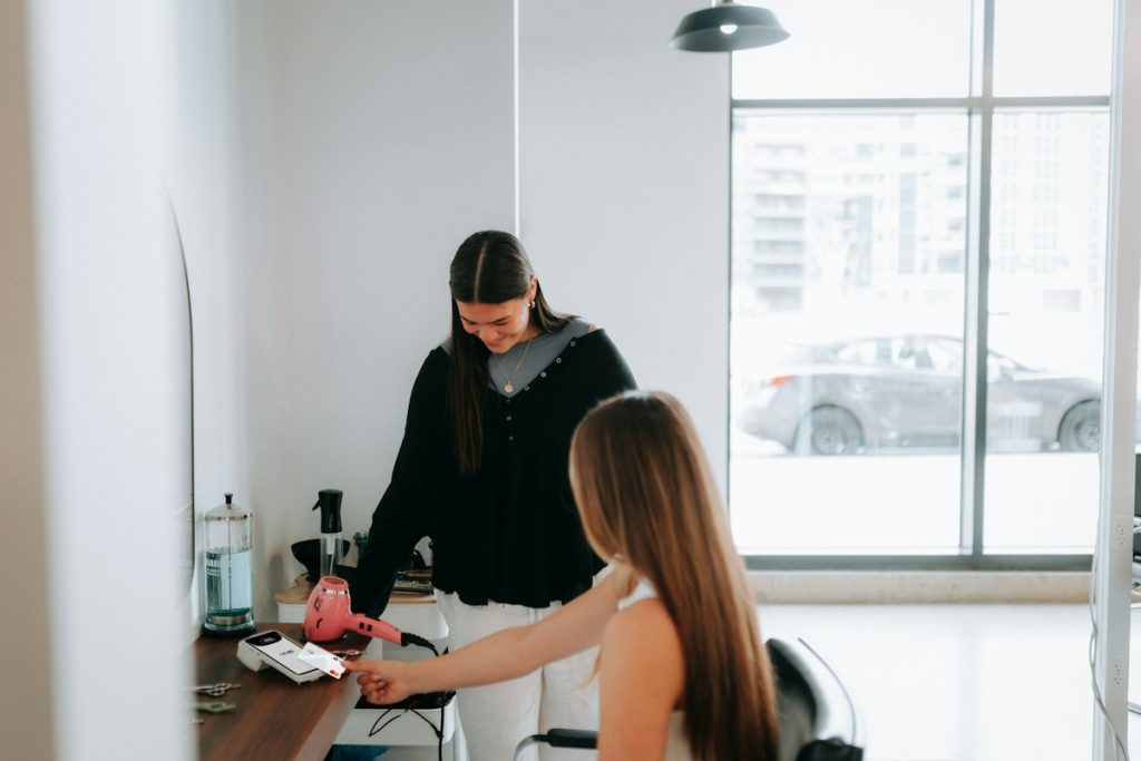 Hair spa: hairdresser preparing a client in a bright salon