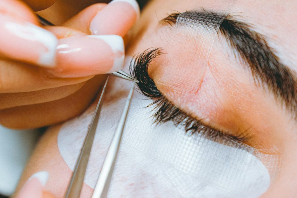 Eyelash extensions: lash artist applying extensions one by one
