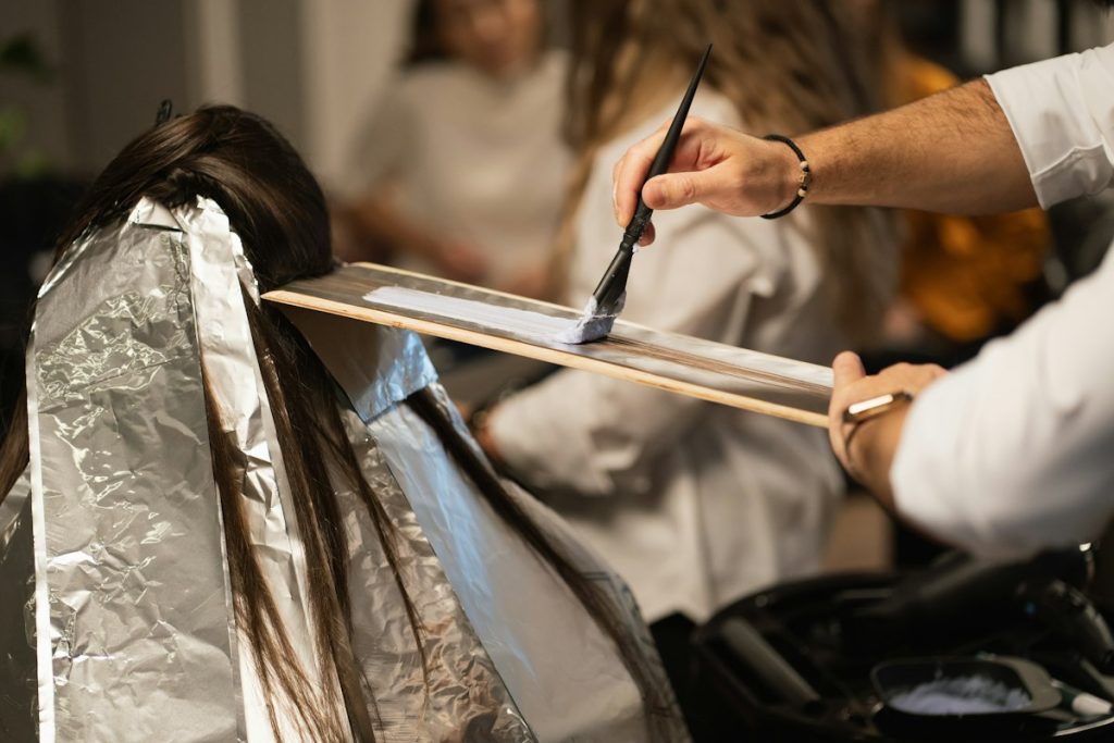 Coloured hair: stylist painting hair colour onto foil