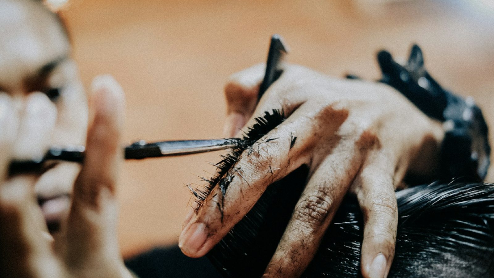 Hair spa help: gloved hands applying a treatment to dark hair