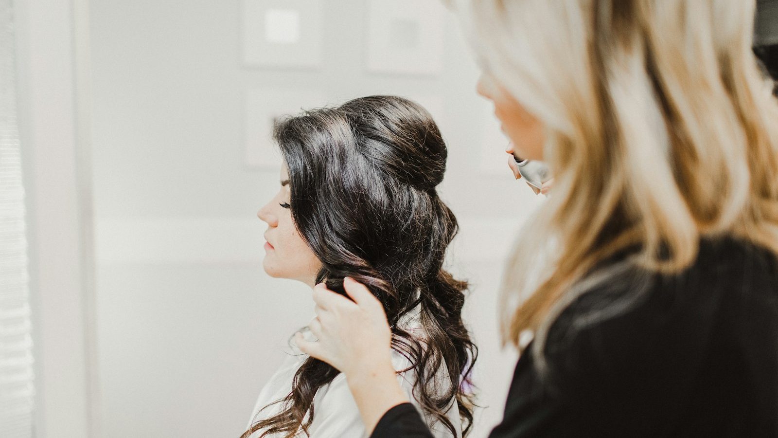 Ladies salon near me open now: stylist creating a half-up wavy hairstyle