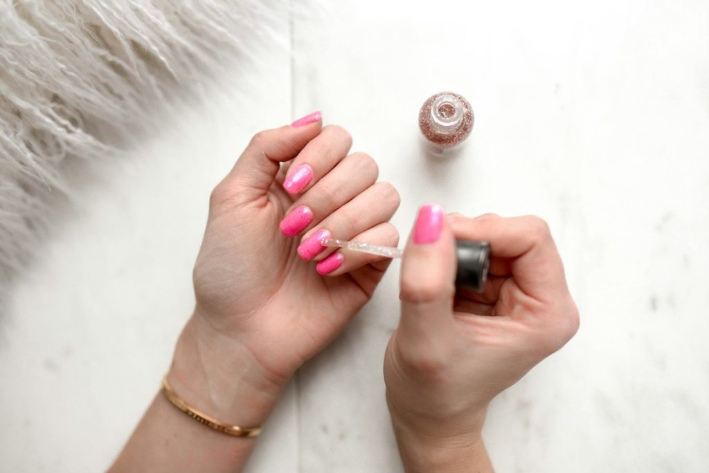 Nail salon near me within 400m: painting nails a bright pink shade