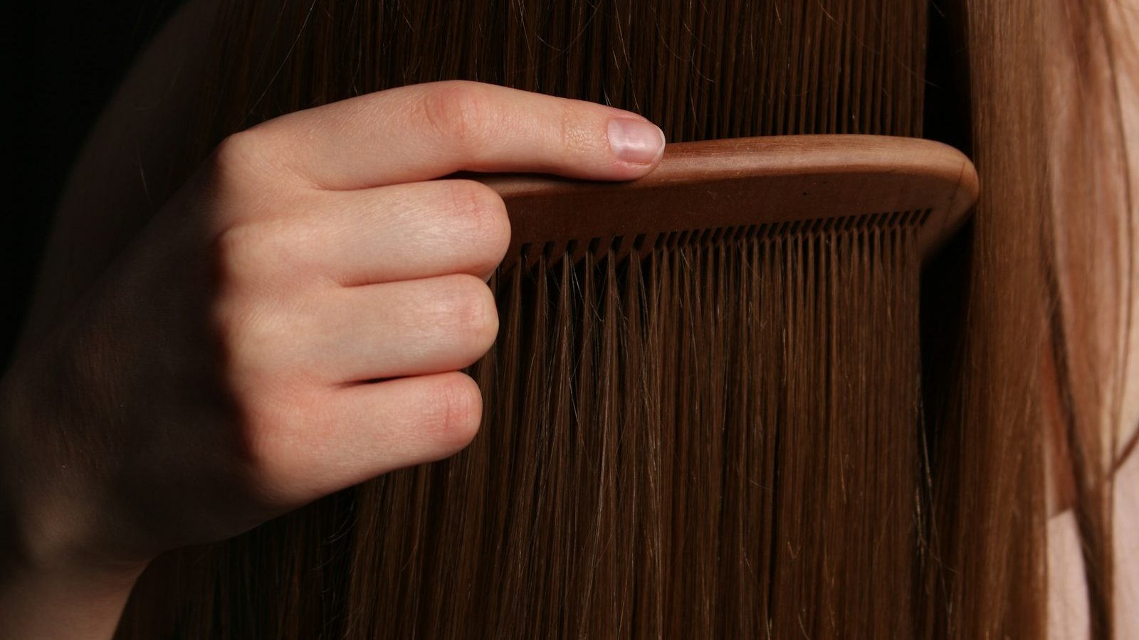 Ladies salon in Majan: wooden comb running through long straight hair
