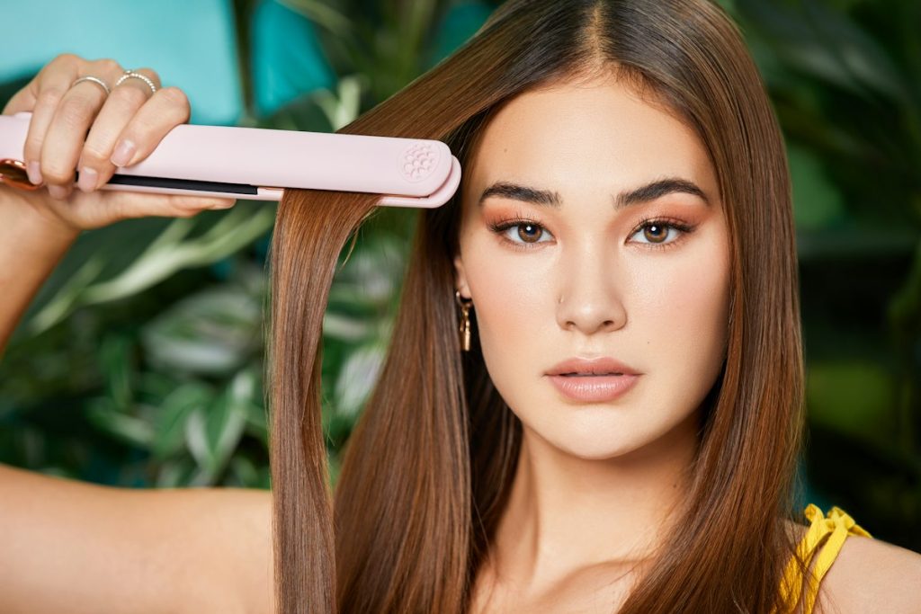 Keratin hair treatment: woman with sleek straight hair and a flat iron