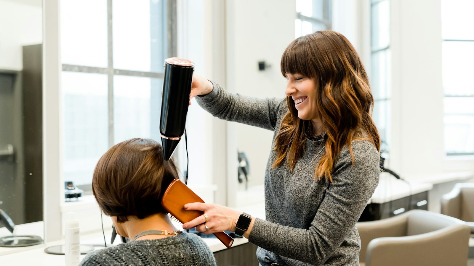 Previously colored hair: stylist blow-drying a client's short hair