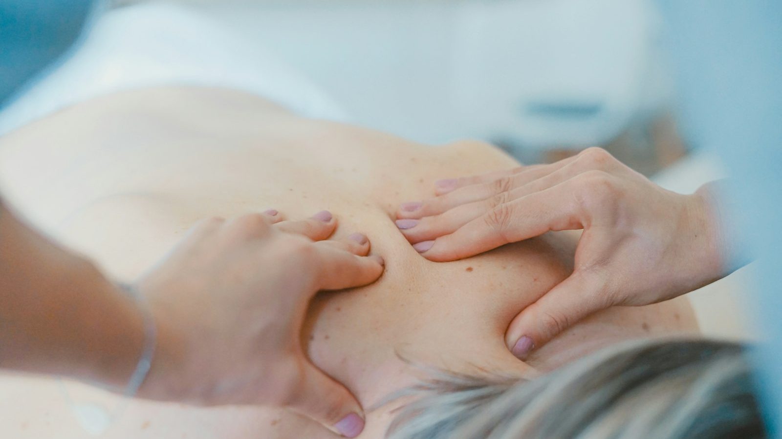 Body massage: therapist massaging a woman's shoulders