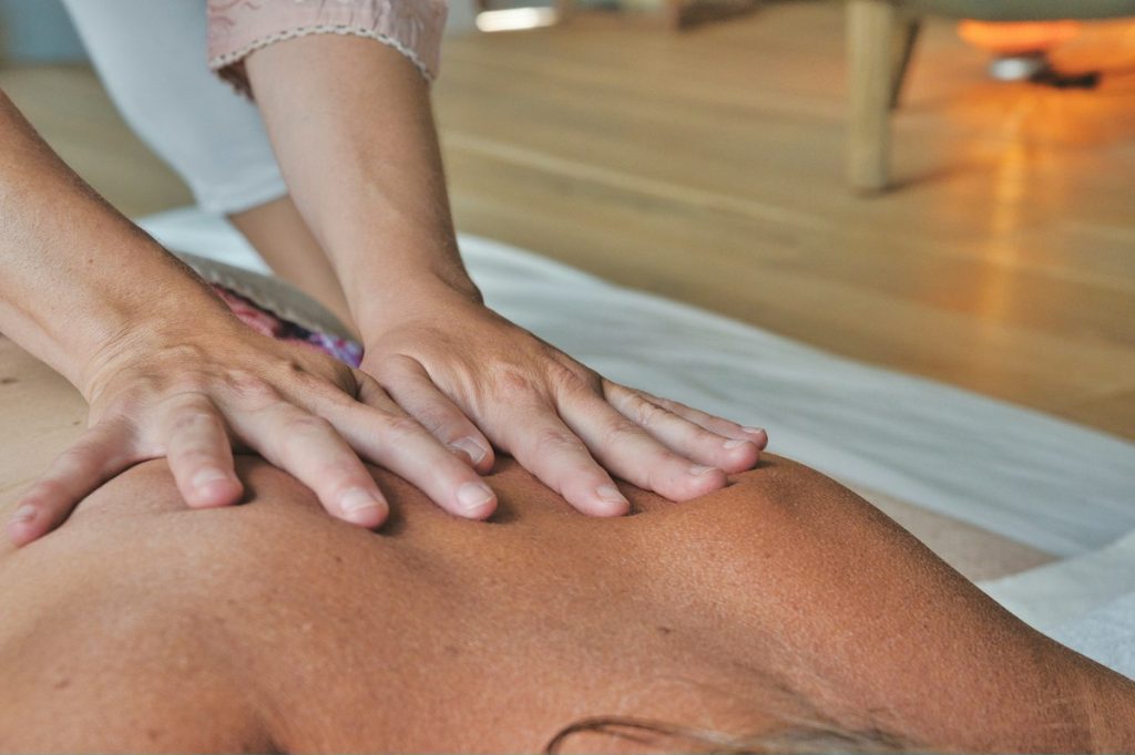 Body massage: hands giving a relaxing back massage