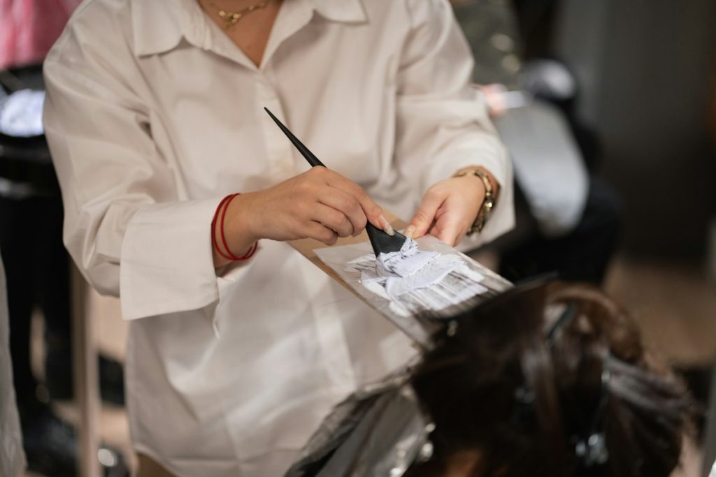 Hair after bleaching: colourist mixing hair colour in a bowl