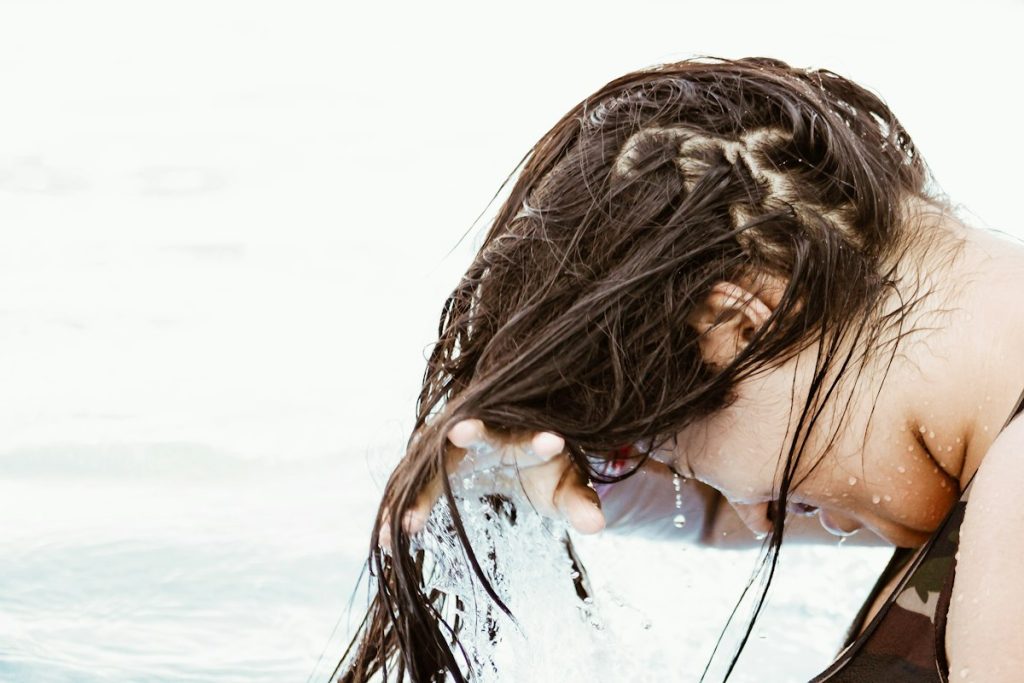 Reduce hair fall: woman rinsing her long wet hair