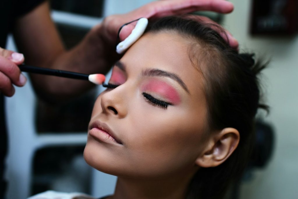 Party makeup artist: makeup artist applying pink party eyeshadow